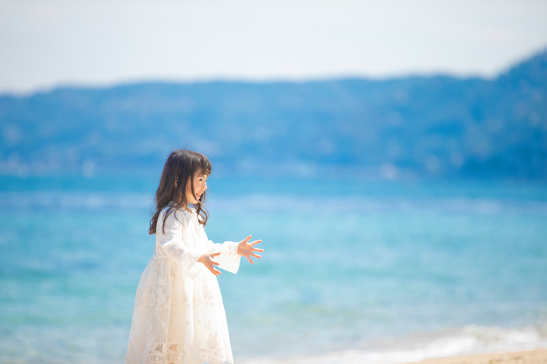 海を背景に笑う女の子の撮影風景